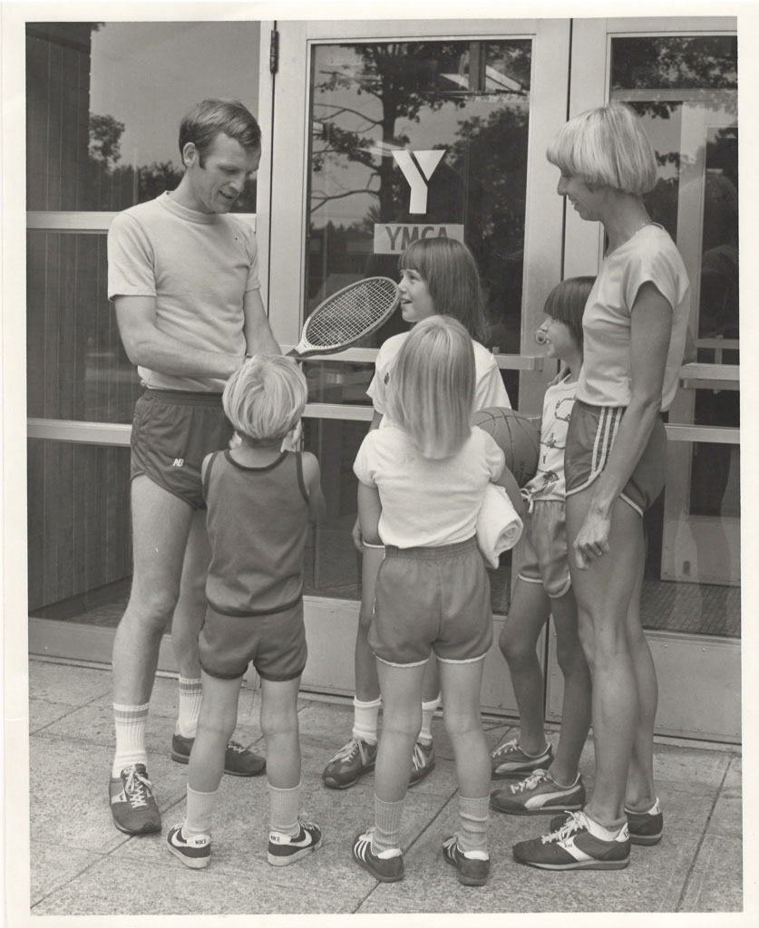 Dr. Sweet as a child with three siblings and parents standing in front of building