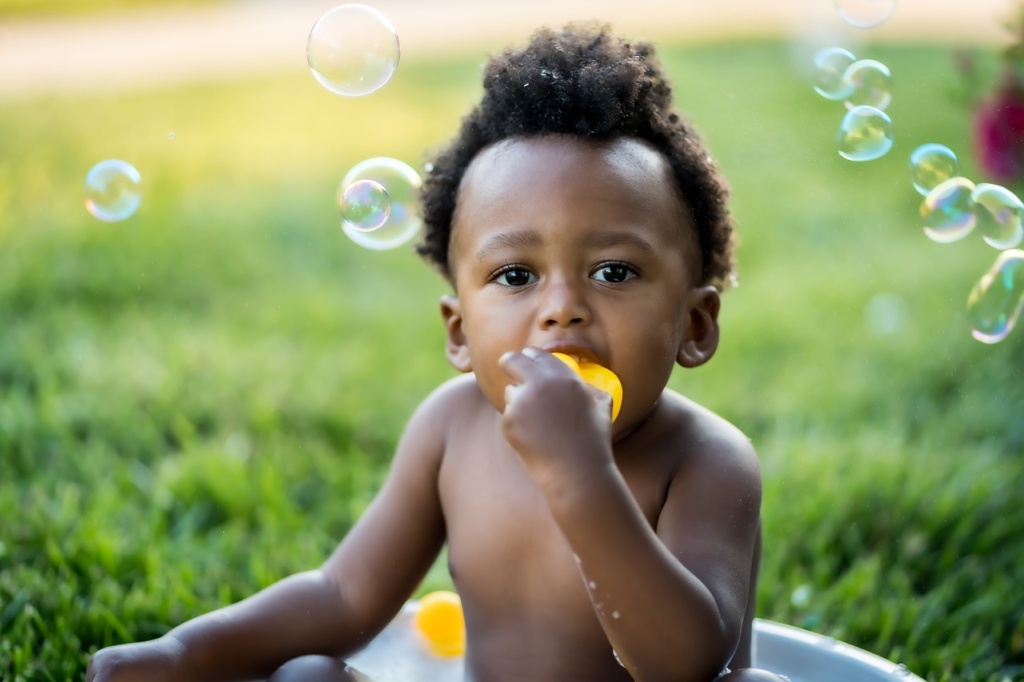 baby in swimming pool with bubbles floating