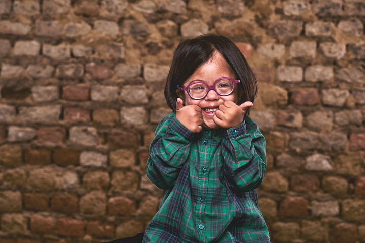 Young girl wearing glasses giving two thumbs up